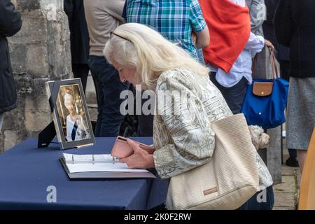 Winchester, Hampshire, Großbritannien. 11.. September 2022. Nach dem Tod von Königin Elisabeth II. Vor drei Tagen unterzeichneten Menschen jeden Alters vor der Großen Halle im Stadtzentrum von Winchester ein Kondolenzbuch am Tag der Proklamation der Aufnahme von König Karl III. Stockfoto