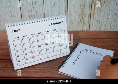 Januar 2023 weißer Tischkalender mit Notizbuch mit Text - To-do-Liste. Kalender- und To-Do-Listenkonzept. Stockfoto