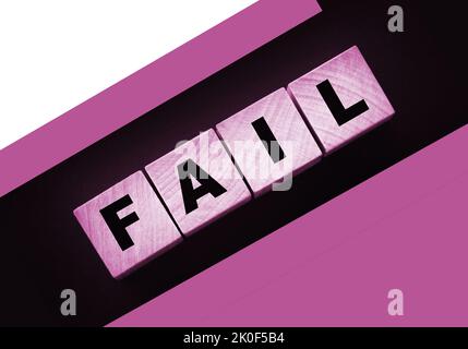 FAIL Word-Text in Holzwürfelblöcken auf schwarzem Hintergrund geschrieben. Krisenkonzept Stockfoto