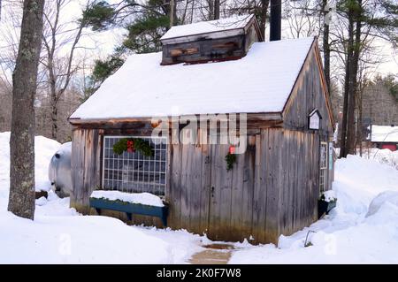 Das Folsom Sugar House ist mit einer Schneedecke bedeckt und für die Weihnachtsferien in, New Hampshire, dekoriert Stockfoto