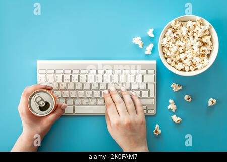 Filme mit Popcorn auf blauem Hintergrund ansehen, flach liegend. Stockfoto