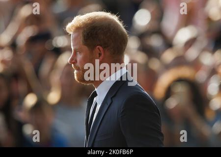 Harry, Herzog von Sussex, blickt auf dem langen Spaziergang vor Windsor Castle auf Blumen, wo nach dem Tod Ihrer Majestät Königin Ehrungen abgelegt wurden Stockfoto