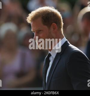 Harry, Herzog von Sussex, blickt auf dem langen Spaziergang vor Windsor Castle auf Blumen, wo nach dem Tod Ihrer Majestät Königin Ehrungen abgelegt wurden Stockfoto