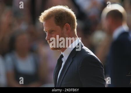 Harry, Herzog von Sussex, blickt auf dem langen Spaziergang vor Windsor Castle auf Blumen, wo nach dem Tod Ihrer Majestät Königin Ehrungen abgelegt wurden Stockfoto