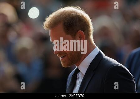 Harry, Herzog von Sussex, blickt auf dem langen Spaziergang vor Windsor Castle auf Blumen, wo nach dem Tod Ihrer Majestät Königin Ehrungen abgelegt wurden Stockfoto