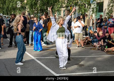 Junge Frauen oder Mädchen, die auf der Kallio Block Party 2022 im finnischen Alpila-Viertel auf der Straße tanzen Stockfoto