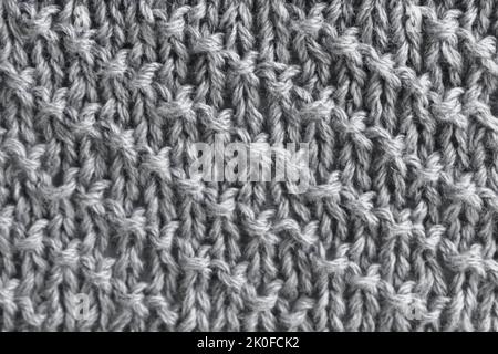 Graues Wolltrikot mit diagonalen Streifen. Kleidung Hintergrund. Stockfoto