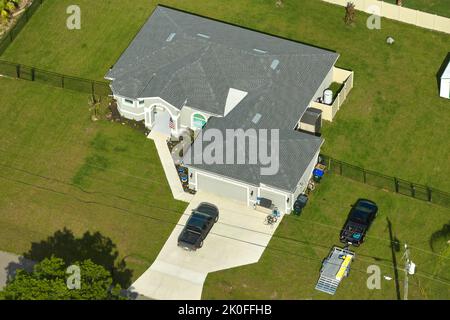 Luftaufnahme eines typischen zeitgenössischen amerikanischen Privathauses mit einer Dachterrasse mit Asphaltschindeln und grünem Rasen auf dem Hof Stockfoto