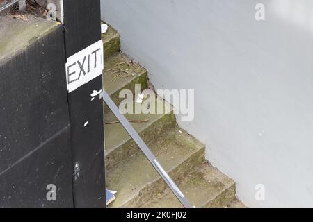 Verlassen Sie das Gebäude in Blockbuchstaben auf einer Treppe Stockfoto