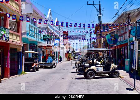 Die Straßen von San Pedro Town, Ambergris Caye, Belize wurden für den St. George's Caye Day und den Belize Independence Day dekoriert, mit der Flagge von Belize. Stockfoto