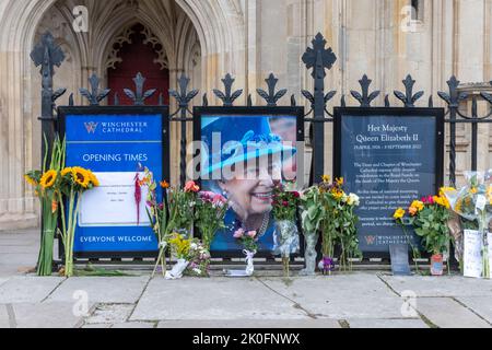 Winchester, Hampshire, Großbritannien. 11.. September 2022. Nach dem Tod von Königin Elizabeth II. Am 8.. September 2022 haben Menschen Blumen und Ehrungen zu Ehren von Königin Elizabeth II. Vor dem Eingang der Winchester Cathedral platziert. Das Land befindet sich bis zu seiner Beerdigung in einer Phase nationaler Trauer. Stockfoto