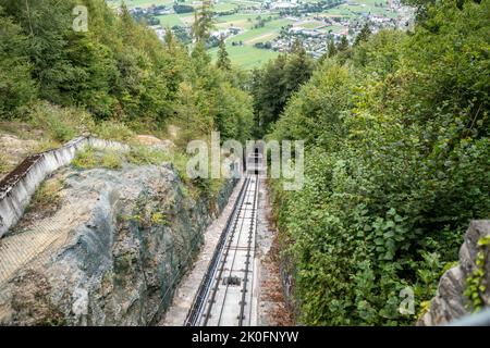 Rote Seilbahn fährt bergab von Harder Kulm, Top of Interlaken. Transport, Tourismus. Stockfoto