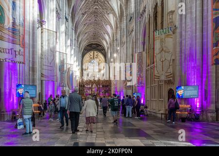 Winchester, Hampshire, Großbritannien. 11.. September 2022. Nach dem Tod von Königin Elizabeth II. Am 8.. September 2022 wurde das Innere der Winchester Cathedral in Purpur beleuchtet, mit Bildern der verstorbenen Königin, Blumen und Gebeten. Viele Menschen sind heute gekommen, um still und leise ihren Respekt zu zollen und ihre Ehrungen zu hinterlassen, indem sie ein Kondolenzbuch unterschrieben oder Kerzen angezündet haben. Das Land befindet sich bis zu seiner Beerdigung in einer Phase nationaler Trauer. Stockfoto