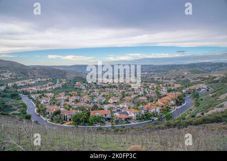 Blick auf eine Unterteilung von einem Bergpfad in San Clemente, Kalifornien. Es gibt ein Grasland an der Vorderseite in der Nähe der reichen Nachbarschaft unten gegen Th Stockfoto