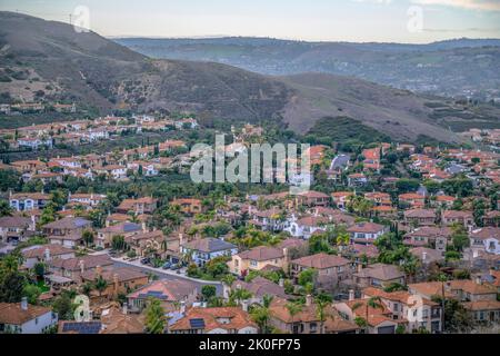 Blick von einem Wanderweg aus auf Villen in einer Unterteilung in San Clemente, Kalifornien. Am Berghang gelegene Wohnanlage mit Blick auf die Bergkette Stockfoto