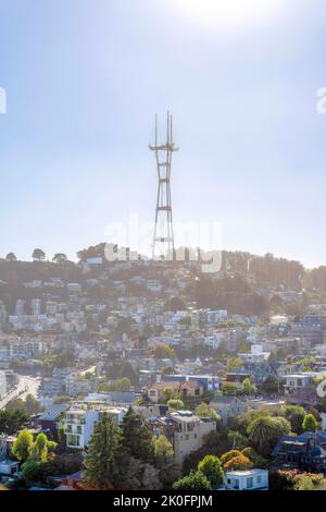 Nebliger Blick auf das Wohngebiet unterhalb des Sutro Tower in San Francisco, Kalifornien. Es gibt Häuser auf einem Hang mit dem Turm auf der Spitze gegen den Himmel backg Stockfoto