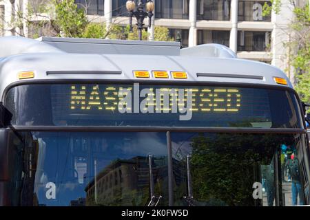 Maskenmandate aufgehoben in vielen Städten RIET ein Bus mit SCHILDERMASKE, die Passagiere zu ermutigen, sich angesichts der kovidierten 19 Bedenken weiterhin zu maskieren Stockfoto