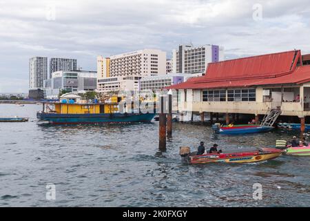 Kota Kinabalu, Malaysia - 23. März 2019: Motorboote mit Besatzung und Passagieren werden auf dem KK Fish Market vertäut. Günstige öffentliche Verkehrsmittel zwischen den Inseln von Stockfoto