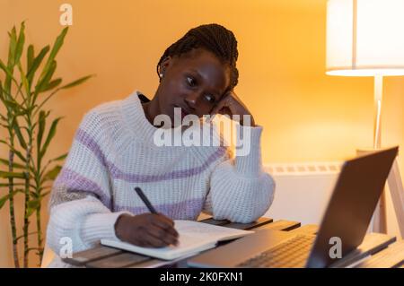 Die junge Dame langweilte sich, während sie Online-Kurse hatte oder zu Hause arbeitete Stockfoto