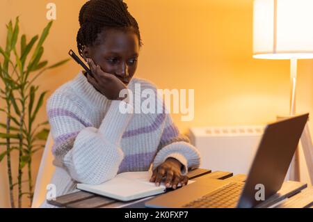 Die junge Dame langweilte sich, während sie Online-Kurse hatte oder zu Hause arbeitete Stockfoto