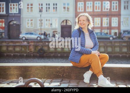 Blonde Mädchen entspannen am Wasser in Nyhavn in Kopenhagen Stockfoto