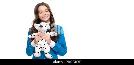 Fröhliches Kind lang lockiges Haar halten Spielzeug isoliert auf weiß, Tierarzt. Banner des Kindes Mädchen mit Spielzeug, Studio-Porträt, Header mit Kopieplatz. Stockfoto