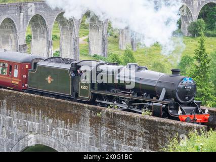 Glenfinnan, Inverness-Shire, Scottish Highlands-July 21 2022:der Zugfahrer winkt und lässt sich an Zuschauer austoben, wie der ikonische Zug, dargestellt in Harry P Stockfoto