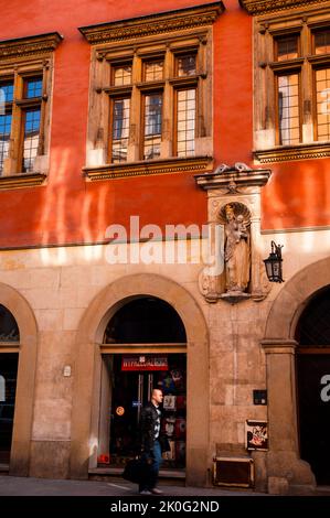 Architektonische Nische mit einer Statue von Maria, die ein Zepter hält und dem Jesuskind, das ein Kreuz hält, und einer alten Lampe mit der Hausnummer 7 in Krakau, Polen. Stockfoto