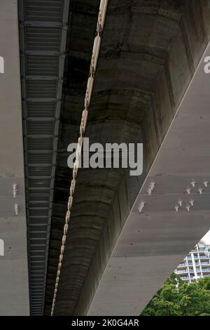 Bei einer Bootstour unter einer Stahl- und Betonbrücke über einen Fluss. Stockfoto