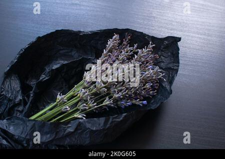 Bouquet von duftenden frischen Lavendelblüten auf dunklem zerknittertem Geschenkpapier Hintergrund Stockfoto
