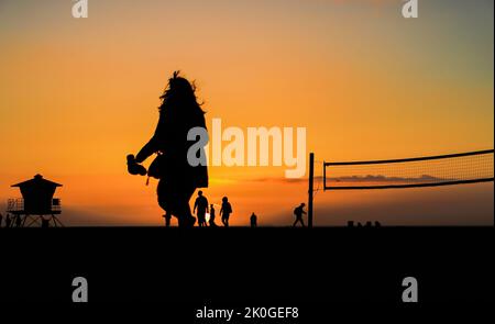 Silhouetten von Menschen am Strand bei Sonnenuntergang Stockfoto