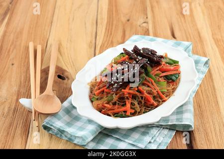 KoreanFood, gebratene Rinder und Glasnudeln mit pflanzlichen Japchae. Gekrönt mit Sesamsamen Stockfoto