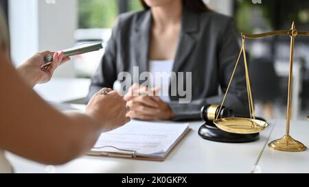 Eine Klientin versucht, ihrem persönlichen Anwalt Bestechung zu gewähren, um eine Klage zu gewinnen. Korruptionskonzept. Freigestellte und Nahaufnahme Hände Bild Stockfoto