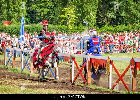 Hever, Großbritannien - 28 Juli, 2013: Zwei Reiter haben schwere Speere Kontakt und Zuschauer auf Hintergrund in turnierenden Ereignis in der Nähe Hever Castle Stockfoto