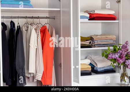 Modernes Ankleidezimmer, ordentlich aufgehängt Kleidung an Kleiderbügel und Regale im Schrank Stockfoto