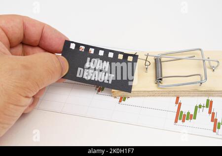 Geschäftskonzept. Auf der Zitatstabelle befindet sich eine Mausefalle, aus der die Hand eine schwarze Platte mit der Aufschrift - Kreditausfall herausnimmt Stockfoto