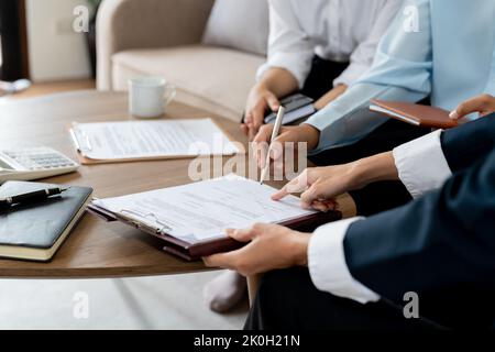 Geschäftsmann beim Lesen von Dokumenten bei der Besprechung, Geschäftspartner, der Vertragsbedingungen vor der Unterzeichnung prüft, ob die rechtlichen Bedingungen des Vertragsrechts erfüllt sind Stockfoto