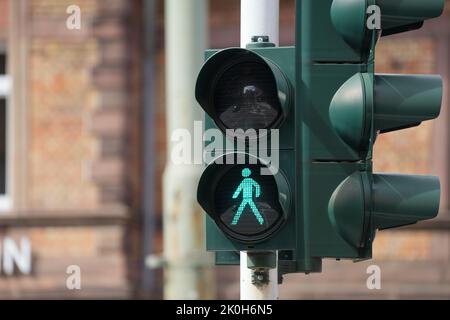 Eine vertikale Nahaufnahme einer Ampel, die ein grünes Licht für Fußgänger auf der Straße zeigt Stockfoto
