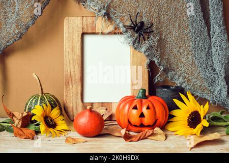 Leerer Bilderrahmen und Kürbisse, Sonnenblumen und trockene Blätter. Halloween-Konzept. Stockfoto