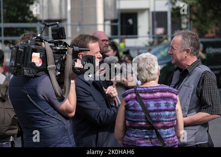 Vor der Beerdigung von Königin Elizabeth interviewt ein Journalist Menschen vor Westminster Abbey. 11.. September 2022 Stockfoto