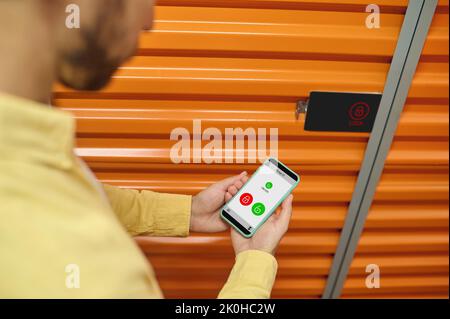 Lagermitarbeiter öffnen das Smart Lock über die Smartphone-App Stockfoto