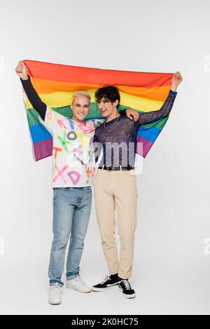 In voller Länge schwulen Mannes und nichtbinäre Person mit lgbtq-Flagge auf grauem Hintergrund, Stockbild Stockfoto