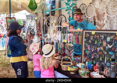 Ein Stand, der Schmuck, Traumfänger und andere bunte Schmuckstücke auf einer Wandermesse verkauft Stockfoto