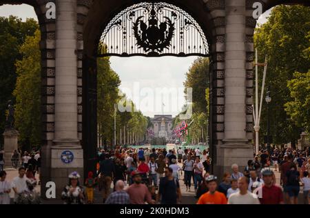 London, Großbritannien. 11. September 2022. Die Menschen gehen durch einen Torbogen zur Straße „The Mall“ vor dem Buckingham Palace. Quelle: Christian Charisius/dpa/Alamy Live News