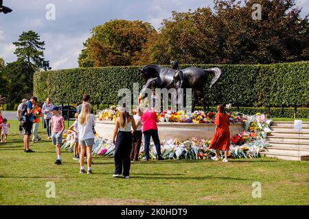 Newmarket, Großbritannien. 11. September 2022. Nach ihrem Tod am 8.. September wurde Königin Elizabeth II. Mit einer von Etienne Millner entworfenen Bronzestatue, die sich am Eingang der Rennbahn Newmarket befindet, ein Geschenk der Stadt im Jahr ihres 90.. Geburtstages, geblümt. Kredit: Mark Bullimore/Alamy Live Nachrichten Stockfoto