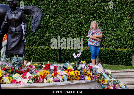 Newmarket, Großbritannien. 11. September 2022. Nach ihrem Tod am 8.. September wurde Königin Elizabeth II. Mit einer von Etienne Millner entworfenen Bronzestatue, die sich am Eingang der Rennbahn Newmarket befindet, ein Geschenk der Stadt im Jahr ihres 90.. Geburtstages, geblümt. Kredit: Mark Bullimore/Alamy Live Nachrichten Stockfoto