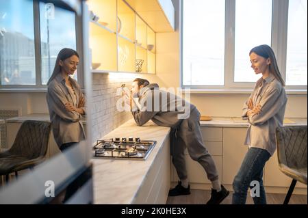 Der Servicetechniker installiert die Steckdose an der Küchenwand Stockfoto