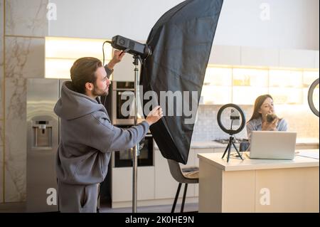 Videoblogger und der Kameramann bereiten sich auf die Aufnahme eines Vlogs vor Stockfoto