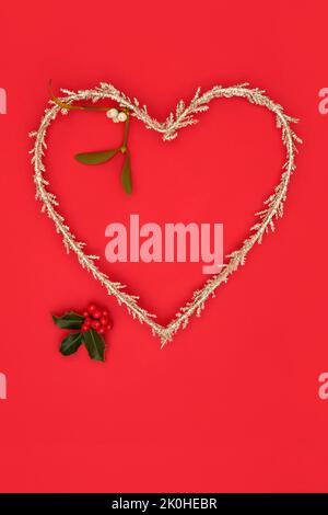 Weihnachten Herz Form Kranz Symbol der Liebe Gold Glitter Baumschmuck mit Stechbeeren und Mistel. Komposition für die festliche Weihnachtszeit. Stockfoto