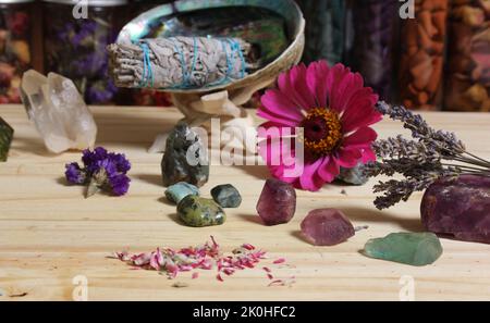 Getrocknete Blumen und Kristall-Chakra-Steine auf Meditationsaltar seichter Freiheitsgrad Stockfoto